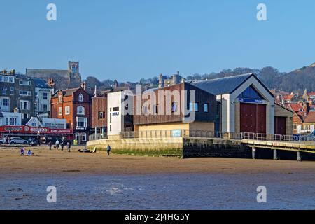 Großbritannien, North Yorkshire, Scarborough Seafront an der South Bay mit Blick auf die RNLI Lifeboat Station und die St. Mary's Church. Stockfoto