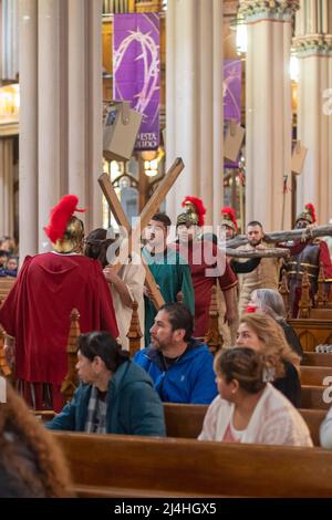 Detroit, Michigan, USA. 15. April 2022. Jesus trägt ein Kreuz und trägt eine Dornenkrone während der Lebendigen Stationen des Kreuzes in der Basilika Ste. Anne de Detroit. Ste. Anne wurde 1701 von französischen Siedlern gegründet. Der Karfreitagsdienst wurde in spanischer Sprache gehalten, was die derzeitige Mitgliedschaft in der Pfarrei widerspiegelt. Kredit: Jim West/Alamy Live Nachrichten Stockfoto