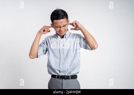 Gestresster junger asiatischer Mann, der den Kopf hält Stockfoto