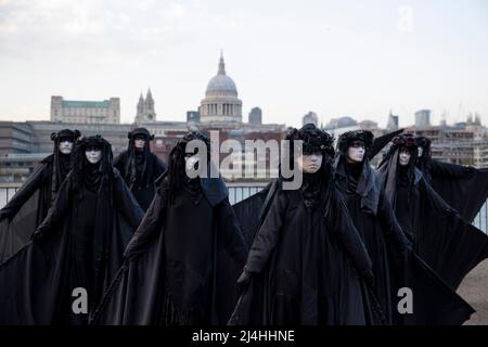 London, Großbritannien. 15. April 2022. Aktivisten werden auf der Bankside auftreten sehen. Aktivisten der Klima-Protestgruppe Extinction Rebellion, die als schwarze Brigaden gekleidet ist, führen in der Öffentlichkeit Pantomimen, Slow-Motion-Bewegungen und Tableaus vor, um gegen die Investition fossiler Brennstoffe durch die britische Regierung und die Auswirkungen fossiler Brennstoffe auf die Umwelt zu protestieren. (Foto von Hesther Ng/SOPA Images/Sipa USA) Quelle: SIPA USA/Alamy Live News Stockfoto