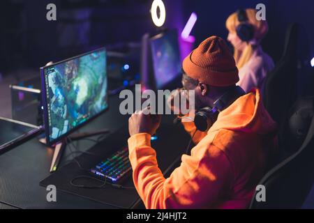 Junger Mann feiert Erfolg während der Teilnahme an eSports Turnier Cyber Sport Concept Medium Nahaufnahme in Innenräumen Neonlichter. Hochwertige Fotos Stockfoto
