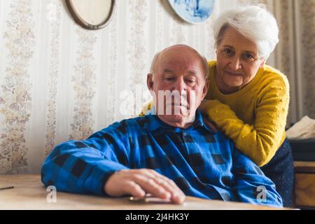 Supportkonzept. Ältere grauhaarige Rentnerin unterstützt ihren Mann, bei dem eine schwere Krankheit diagnostiziert wurde. Hochwertige Fotos Stockfoto