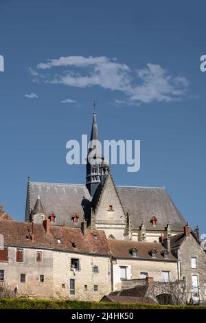 MONTRESOR, FRANKREICH - 24.. MÄRZ 2022: Blick auf die Stiftskirche St. Johannes des Täufers hinter einigen traditionellen Häusern Stockfoto