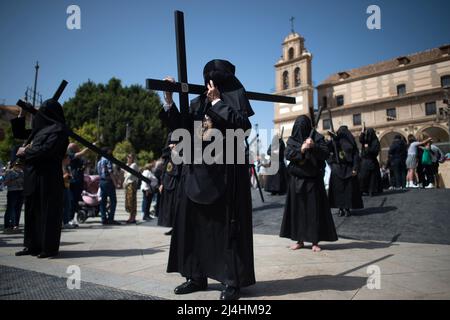 Ein Büßer der Bruderschaft „Monte Calvario“ wird mit einem Kreuz gesehen, als er an einer Prozession während des Karfreitags teilnimmt, um die Feierlichkeiten der Karwoche zu feiern. Nach zwei Jahren ohne Karwoche aufgrund der Coronavirus-Pandemie warten Tausende von Gläubigen darauf, die Prozessionen mit den Statuen von Christus und der Jungfrau Maria im Rahmen der traditionellen Karwoche auf den Straßen zu sehen. In Andalusien versammelt die Karwoche Tausende von Menschen aus allen Ländern und gilt als eines der wichtigsten religiösen und kulturellen Ereignisse des Jahres. Stockfoto