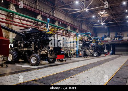 Prozess der Montage von landwirtschaftlichen Traktoren oder Mähdreschern in der Werkstatt Stockfoto