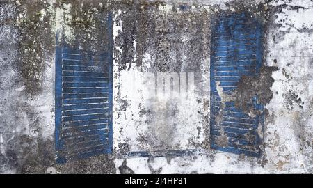 Abblätternde Zementwand mit weißer und grauer Farbe und blauen Fensterläden in offener Position. Platz für Kopie Stockfoto