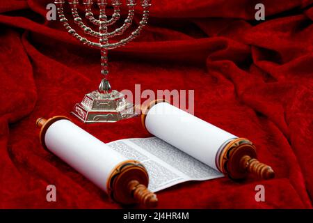 Happy Hanukkah, religiöse Spiritualität und Betende Konzept Thema mit Menora und Torah Rollen isoliert auf rotem Samt Hintergrund mit Copy Space in J Stockfoto