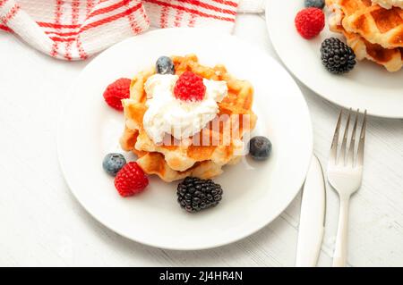 Gesundes Frühstück, gesundes Dessert und Waffel-Snack-Konzept mit einem Teller mit belgischen Waffeln mit Heidelbeeren, Brombeeren, Himbeeren und w Stockfoto