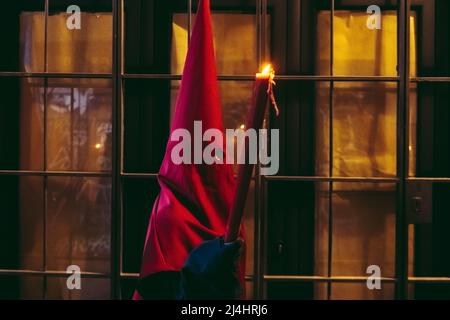 Barcelona, Spanien. 15. April 2022. Während der Karfreitagsprozession zieht ein mit Kapuze behauener Büßer der Bruderschaft "Nuestra Senora de las Angustias" durch Barcelona.Quelle: Matthias Oesterle/Alamy Live News Stockfoto