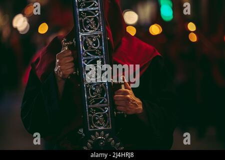 Barcelona, Spanien. 15. April 2022. Ein Verehrer der Bruderschaft "Nuestra Senora de las Angustias" trägt während der Karfreitagsprozession durch Barcelona ein Kreuz.Quelle: Matthias Oesterle/Alamy Live News Stockfoto