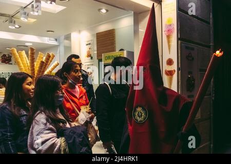 Barcelona, Spanien. 15. April 2022. Während der Karfreitagsprozession zieht ein mit Kapuze behauener Büßer der Bruderschaft "Nuestra Senora de las Angustias" durch Barcelona.Quelle: Matthias Oesterle/Alamy Live News Stockfoto