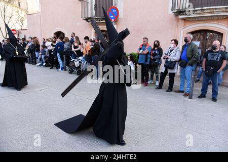 Torredembarra, Spanien. 15. April 2022. Während der Prozession der heiligen Beerdigung Jesu Christi in Torredembarra am Osterfreitag trägt ein mit Kapuze versehener Büßer ein Kreuz. Am Osterfreitag wird in der Stadt Torredembarra (Spanien) die Prozession der Heiligen Beerdigung gefeiert, die das Begräbnis Jesu Christi nach der Kreuzigung symbolisiert. Kredit: SOPA Images Limited/Alamy Live Nachrichten Stockfoto