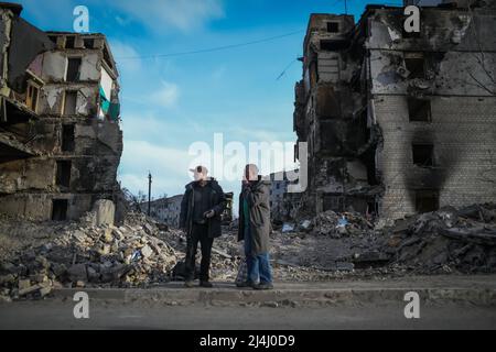 Ukraine. 15. April 2022. Borodyanka, bei Kiew, Ukraine - 15. April 2022: Männer vor Gebäuden, die während der russischen Besatzung durch Schüsse im Zentrum von Borodyanka beschädigt wurden. Russische Streitkräfte betraten das Territorium der Ukraine am 24. Februar 2022. (Foto: Piero Cruciatti/Sipa USA) Quelle: SIPA USA/Alamy Live News Stockfoto