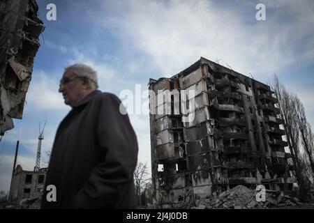 Ukraine. 15. April 2022. Borodyanka, in der Nähe von Kiew, Ukraine - 15. April 2022: Ein Mann geht vor Gebäude, die während der russischen Besatzung durch Schüsse im Zentrum von Borodyanka beschädigt wurden. Russische Streitkräfte betraten das Territorium der Ukraine am 24. Februar 2022. (Foto: Piero Cruciatti/Sipa USA) Quelle: SIPA USA/Alamy Live News Stockfoto