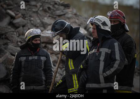 Ukraine. 15. April 2022. Borodyanka, in der Nähe von Kiew, Ukraine - 15. April 2022: Rettungsmannschaften ruhen auf dem Gelände eines beschädigten Gebäudes im Zentrum von Borodyanka. Russische Streitkräfte betraten das Territorium der Ukraine am 24. Februar 2022. (Foto: Piero Cruciatti/Sipa USA) Quelle: SIPA USA/Alamy Live News Stockfoto