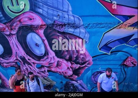 Blick auf Menschen aus der Höhe gegen die Graffiti-Wand Stockfoto