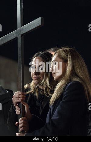 Albina (R) aus Russland und Irina (L) aus der Ukraine tragen das Kreuz auf dem Kreuzweg am Abend des Karfreitags (Ostern) am Kolosseum in Rom, Italien, am 15. April 2022. Der Höhepunkt der Meditationen kam in der Station 13., wo die beiden Frauen das Kreuz zusammen tragen sahen. Die beiden Frauen, Freunde und beide Krankenschwestern in Rom, hielten das Kreuz fest und schauten einander in die Augen in einem Blick, der den Schmerz der Kriegsbrüder und die unsterblicher Hoffnung auf Frieden und Versöhnung zu vermitteln schien. Die traditionelle Via Crucis unter dem Vorsitz von Papst Franziskus kehrte am Karfreitagabend zurück Stockfoto