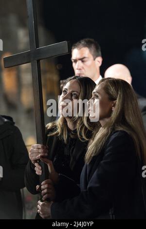 Albina (R) aus Russland und Irina (L) aus der Ukraine tragen das Kreuz auf dem Kreuzweg am Abend des Karfreitags (Ostern) am Kolosseum in Rom, Italien, am 15. April 2022. Der Höhepunkt der Meditationen kam in der Station 13., wo die beiden Frauen das Kreuz zusammen tragen sahen. Die beiden Frauen, Freunde und beide Krankenschwestern in Rom, hielten das Kreuz fest und schauten einander in die Augen in einem Blick, der den Schmerz der Kriegsbrüder und die unsterblicher Hoffnung auf Frieden und Versöhnung zu vermitteln schien. Die traditionelle Via Crucis unter dem Vorsitz von Papst Franziskus kehrte am Karfreitagabend zurück Stockfoto