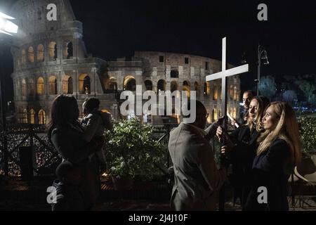 Albina (R) aus Russland und Irina (L) aus der Ukraine tragen das Kreuz auf dem Kreuzweg am Abend des Karfreitags (Ostern) am Kolosseum in Rom, Italien, am 15. April 2022. Der Höhepunkt der Meditationen kam in der Station 13., wo die beiden Frauen das Kreuz zusammen tragen sahen. Die beiden Frauen, Freunde und beide Krankenschwestern in Rom, hielten das Kreuz fest und schauten einander in die Augen in einem Blick, der den Schmerz der Kriegsbrüder und die unsterblicher Hoffnung auf Frieden und Versöhnung zu vermitteln schien. Die traditionelle Via Crucis unter dem Vorsitz von Papst Franziskus kehrte am Karfreitagabend zurück Stockfoto