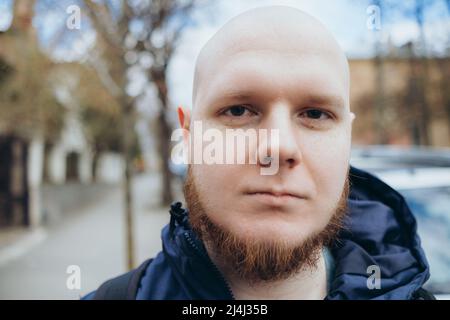 Ein weißer Mann mit Glatze und Bart rast in einem Park aus nächster Nähe aus. Stockfoto
