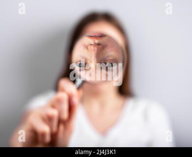 Verzerrtes Selbstwahrnehmungskonzept. Frau Gesicht auf Lupe umgedreht. Psychologische Probleme. Hochwertige Fotos Stockfoto