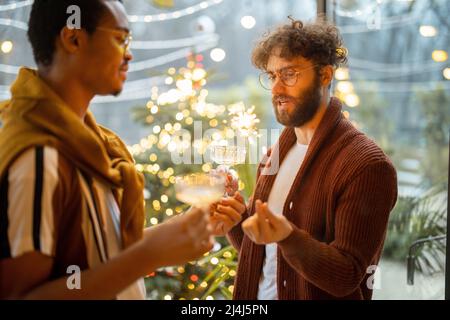 Zwei männliche Freunde feiern mit Wein im Hinterhof Stockfoto