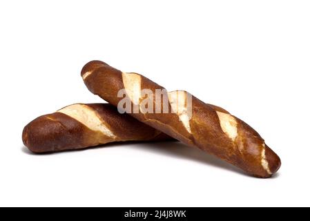 Nahaufnahme von zwei frisch gebackenen traditionellen Tiroler Brotstäbchen namens Laugenstangerl, übereinander auf weißem Hintergrund gestapelt Stockfoto