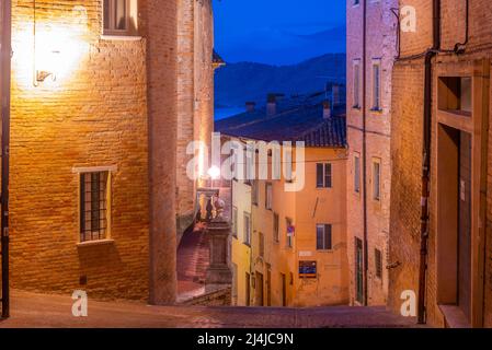 Sonnenaufgang Blick auf eine schmale Straße in der Altstadt von Urbino in Italien. Stockfoto