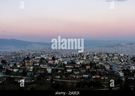 Blick auf Izmir City. Rosafarbener Himmel und Berge über der Stadt Stockfoto