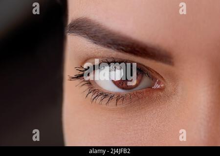 Schöne Makroaufnahme des weiblichen Auges mit extrem langen Wimpern und schwarzem Liner Make-up. Perfektes Make-up und lange Wimpern. Kosmetik und Make-up. Cl Stockfoto