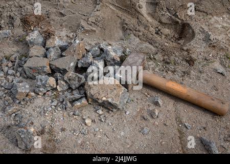 Ein schwerer Hammer lag auf dem Boden und zerschlug Beton für Abriss und industrielle Nutzung Stockfoto