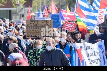 Hannover, Deutschland. 16. April 2022. Demonstranten mit Plakaten 'Stoppt den Krieg! Solidarität mit der Ukraine“ und „Stoppt Putins Krieg“ am Ostermarsch 2022. Unter dem Motto 'Kriege töten. Rüstungen zerstören und verarmen. Nur Verhandlungen bringen Frieden", demonstrieren mehrere hundert Teilnehmer auf dem Ostermarsch in Hannover. Quelle: Julian Stratenschulte/dpa/Alamy Live News Stockfoto