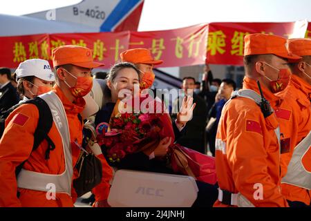 Peking, China. 16. April 2022. Astronautin Wang Yaping winkt der Menge bei ihrer Ankunft in Peking, der Hauptstadt Chinas, am 16. April 2022 zu. Drei chinesische Astronauten des bemannten Raumschiffs Shenzhou-13 haben ihre sechsmonatige Raumstation-Mission abgeschlossen und sind am Samstag sicher zur Erde zurückgekehrt. Die Rückfahrkapsel von Shenzhou-13, die die Astronauten Zhai Zhigang, Wang Yaping und Ye Guangfu trug, landete um 9:56 Uhr morgens (Pekinger Zeit) auf dem Dongfeng-Landeplatz in der Autonomen Region Innere Mongolei im Norden Chinas. Quelle: Xinhua/Alamy Live News Stockfoto