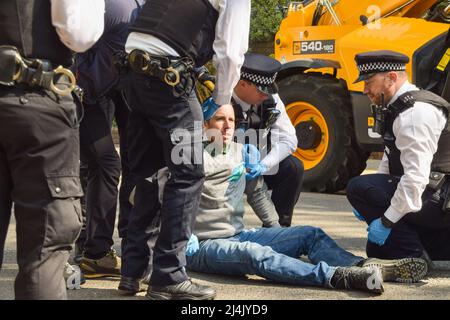 London, Großbritannien, 16.. April 2022. Die Polizei entfernt und verhaftete Etienne Stott. Der olympische Goldmedaillengewinnerin kletterte zusammen mit einem anderen Aktivisten auf einen Shell-Tanker und blockierte eine Straße in Bayswater, während mehrere Demonstranten des Extinction Rebellion Unterstützung leistten. Der Sportler und Aktivist fordert ein Ende der fossilen Brennstoffe und fordert die Regierung auf, gegen die Klimakrise zu handeln. Kredit: Vuk Valcic/Alamy Live Nachrichten Stockfoto