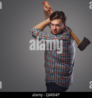 Porträt eines bärtigen Mannes mit Axt, der im Studio posiert Stockfoto