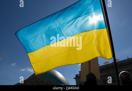 Berlin, Deutschland. 16. April 2022. Bei der Demonstration gegen den Krieg in der Ukraine weht eine Flagge der Ukraine im Wind. Quelle: Paul Zinken/dpa/Alamy Live News Stockfoto