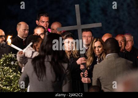 Rom, Italien. 15. April 2022. Krankenschwestern, Albina (R) aus Russland und Irina (L) aus der Ukraine halten das Kreuz, während sie an der Via Crucis teilnehmen. Papst Franziskus führt am Karfreitag in Rom die Fackelprozession der Via Crucis (Kreuzweg) am alten Kolosseum (Colosseo) vor. Christen auf der ganzen Welt begehen die Karwoche, gedenken der Kreuzigung Jesu Christi, die zu seiner Auferstehung am Ostern führt. (Foto: Stefano Costantino/SOPA Images/Sipa USA) Quelle: SIPA USA/Alamy Live News Stockfoto