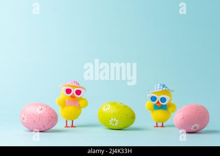 Lustige Hühnerpuppen mit bunten Ostereiern. Minimales Osterkonzept. Stockfoto