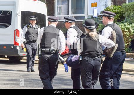 London, Großbritannien, 16.. April 2022. Die Polizei entferne und verhaftete einen Demonstranten, der sich auf dem Tanker befand. Der olympische Goldmedaillengewinnerin Etienne Stott kletterte zusammen mit einem anderen Aktivisten auf einen Shell-Tanker und blockierte eine Straße in Bayswater, während mehrere Demonstranten der Extinction Rebellion Unterstützung leistten. Der Sportler und Aktivist fordert ein Ende der fossilen Brennstoffe und fordert die Regierung auf, gegen die Klimakrise zu handeln. Kredit: Vuk Valcic/Alamy Live Nachrichten Stockfoto