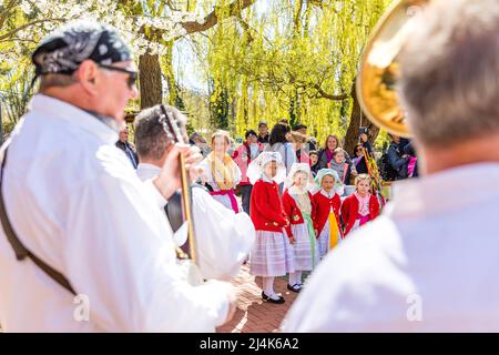 16. April 2022, Brandenburg, Lübben: Kinder der Kita Spreewald und der Liuba-Grundschule in Lübben stehen mit ihrem Lehrer in traditioneller Spreewald-Tracht bei der Übergabe des Rudel am Lübbener Hafen. Traditionell wird am Osterwochenende in Lübben der "Frühlingsbeginn" gefeiert. Am Hafen findet die rudel- und Paddelübergabe zum offiziellen Start der Saison der Kahn- und Paddelboote statt. Ein rudel ist eine hölzerne Vorrichtung, die von Bargemen benutzt wird, um ihren Lastkahn durch die Wasserwege des Spreewalds zu bewegen. Diese Aktivität wird als „Aufnahme“ bezeichnet. Foto: Frank Hammerschmidt/dpa Stockfoto