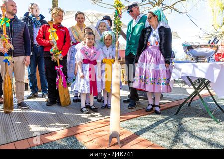 16. April 2022, Brandenburg, Lübben: Teilnehmer des Rudel- und Paddelübergangs stehen im Hafen von Lübben. Traditionell wird am Osterwochenende in Lübben der "Frühlingsbeginn" gefeiert. Die rudel- und Paddelübergabe zum offiziellen Start der Saison für die Kahn- und Paddelboote findet am Hafen statt. Ein rudel ist eine hölzerne Vorrichtung, die von Bargemen benutzt wird, um ihren Lastkahn durch die Wasserwege des Spreewalds zu bewegen. Diese Aktivität wird als „Aufnahme“ bezeichnet. Stockfoto