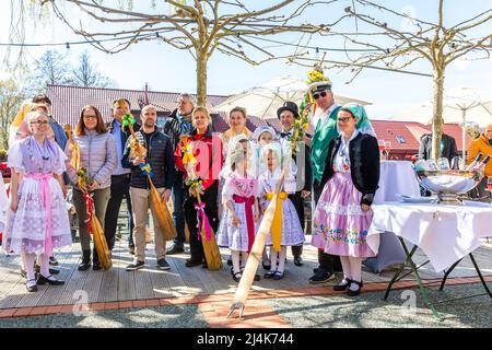 16. April 2022, Brandenburg, Lübben: Teilnehmer des Rudel- und Paddelübergangs stehen im Hafen von Lübben. Traditionell wird am Osterwochenende in Lübben der "Frühlingsbeginn" gefeiert. Die rudel- und Paddelübergabe zum offiziellen Start der Saison für die Kahn- und Paddelboote findet am Hafen statt. Ein rudel ist eine hölzerne Vorrichtung, die von Bargemen benutzt wird, um ihren Lastkahn durch die Wasserwege des Spreewalds zu bewegen. Diese Aktivität wird als „Aufnahme“ bezeichnet. Stockfoto