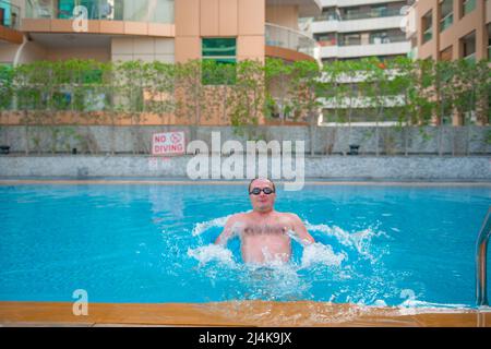 Starker Sportler in Brille schwimmt in einem großen Pool Stockfoto