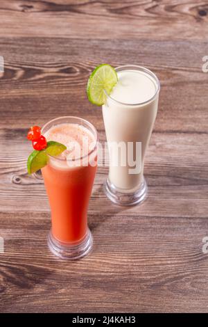 Hohe Gläser mit natürlichen roten Früchten und Kokosnusssäften Stockfoto