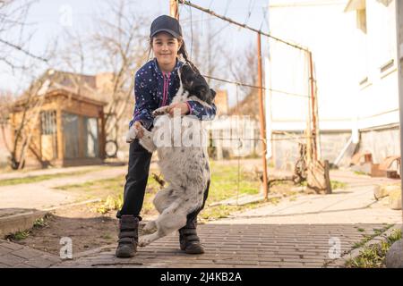 Kleines Mädchen, das mit einem Hund tanzt Stockfoto