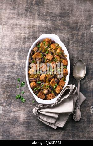 Vegane Füllung mit Pilzen, Lauch und knusprigen Croutons auf Holztisch, Draufsicht. Traditionelles Thanksgiving-Menü Stockfoto