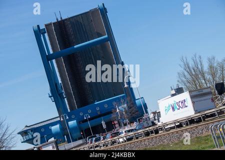 Wolgast, Deutschland. 16. April 2022. Vor der Peenebrücke in Wolgast auf der Insel Usedom stecken Fahrzeuge im Stau. Mehrmals am Tag öffnet sich die kombinierte Eisenbahn- und Straßenbrücke zur Insel Usedom, um Schifffahrt in die Ostsee zu ermöglichen. Quelle: Stefan Sauer/dpa/Alamy Live News Stockfoto