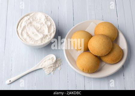 Hausgemachte glutenfreie Quark-Reiskekse und Schüssel Reismehl auf hellem Hintergrund, selektiver Fokus. Leckeres gesundes Essen Stockfoto
