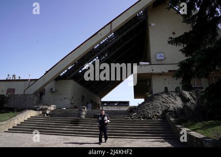 TROSTIANETS, UKRAINE - 15. APRIL 2022 - Ein Mann läuft vom Passagierterminal des Bahnhofs Trostianets-Smorodyne, der infolge dessen zerstört wurde Stockfoto