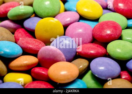 Nahaufnahme eines Stapels von Smarties, mehrfarbigen, knusprig geschälten Schokoladenbonbons. Stockfoto